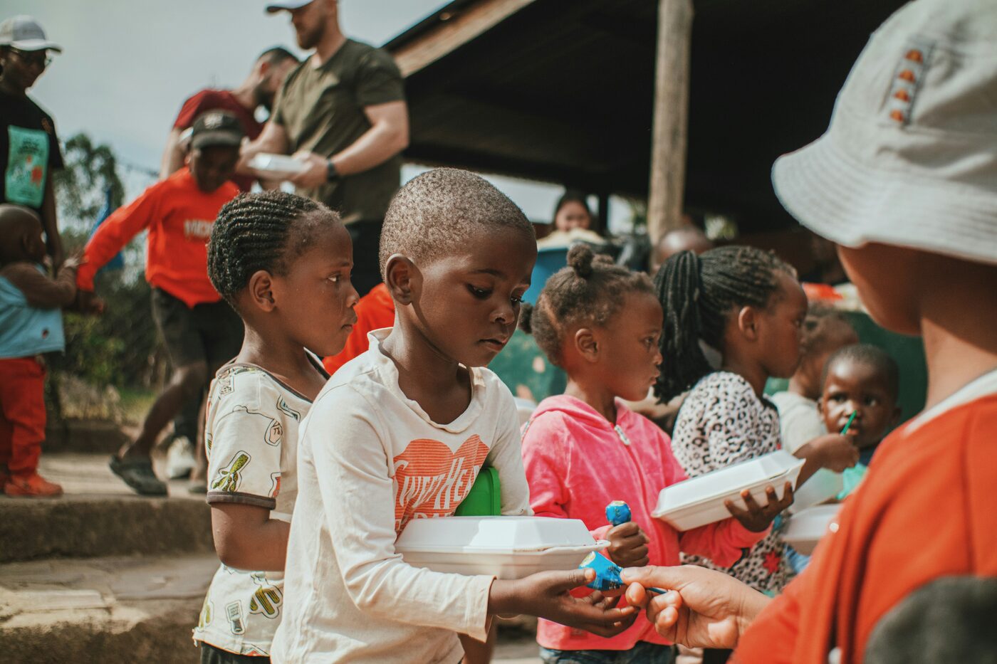Children receiving meals at a community distribution